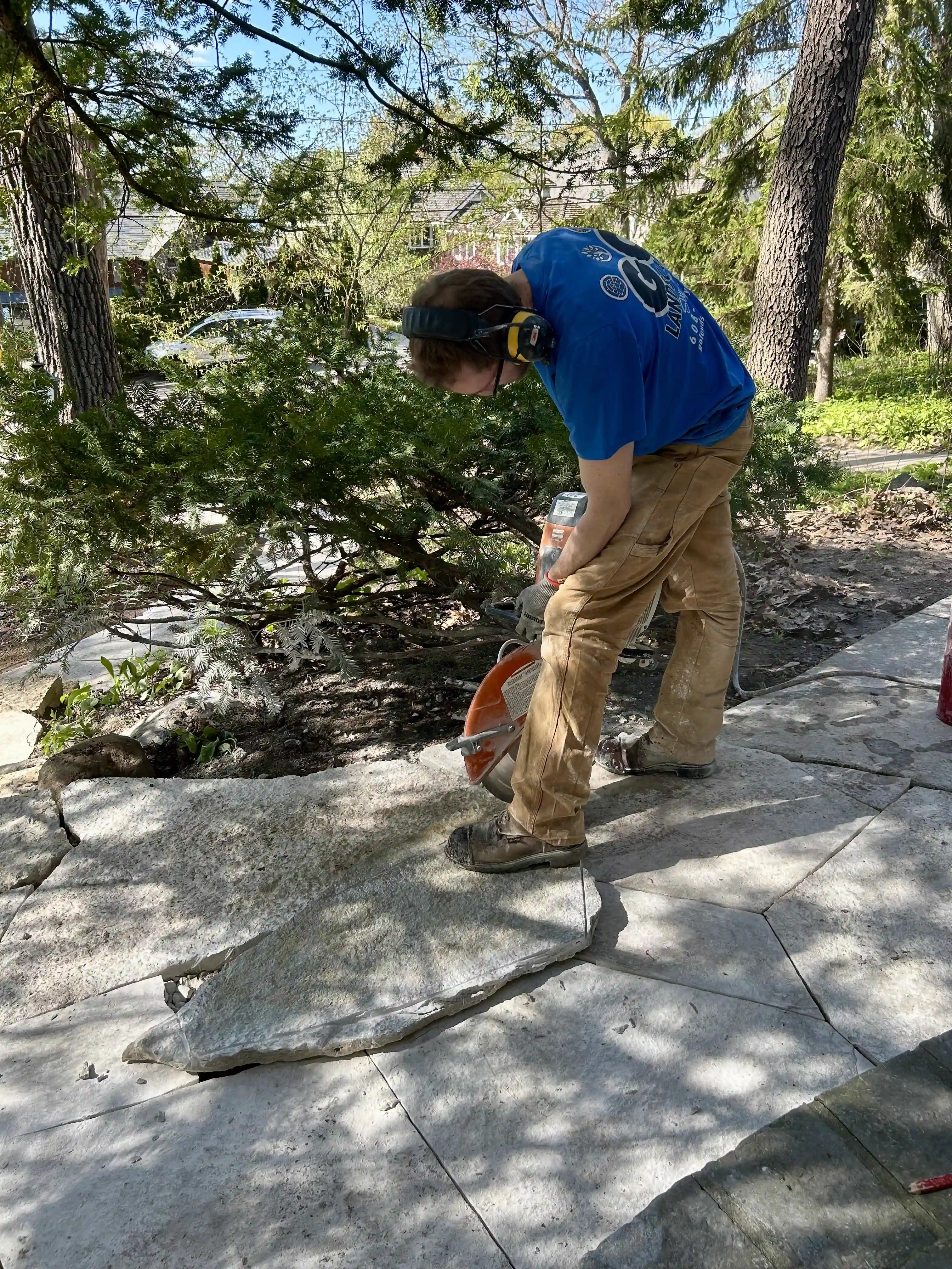 GO Landscaping crew member cutting flagstone on site