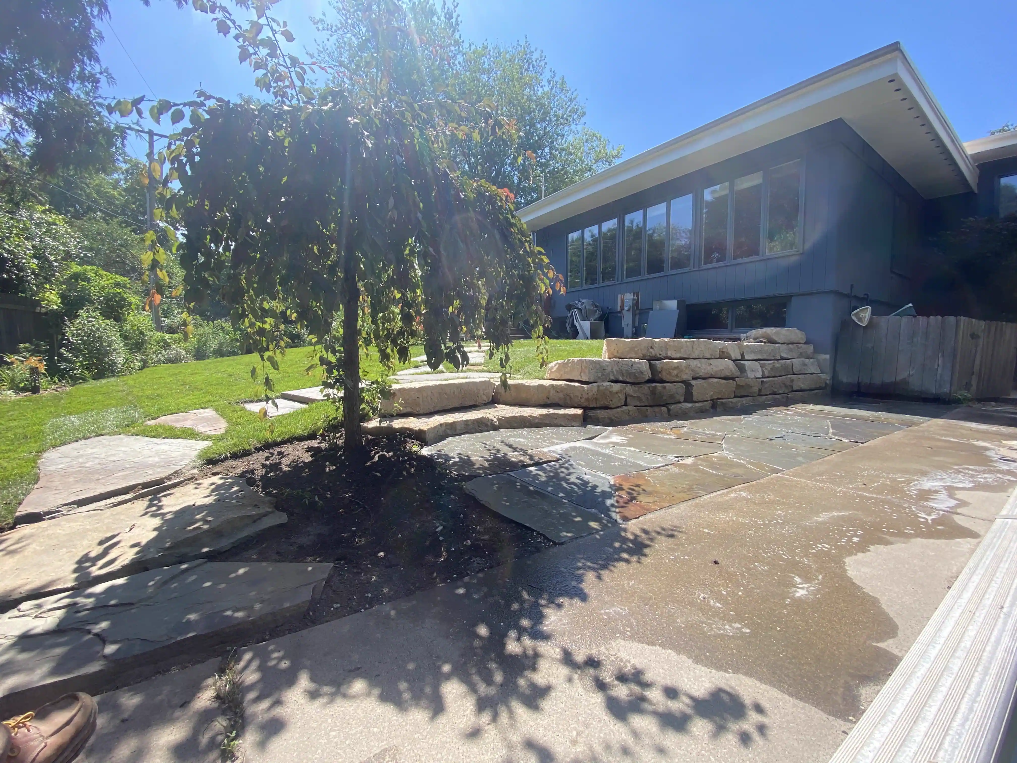 Finished flagstone patio with a weeping cherry tree