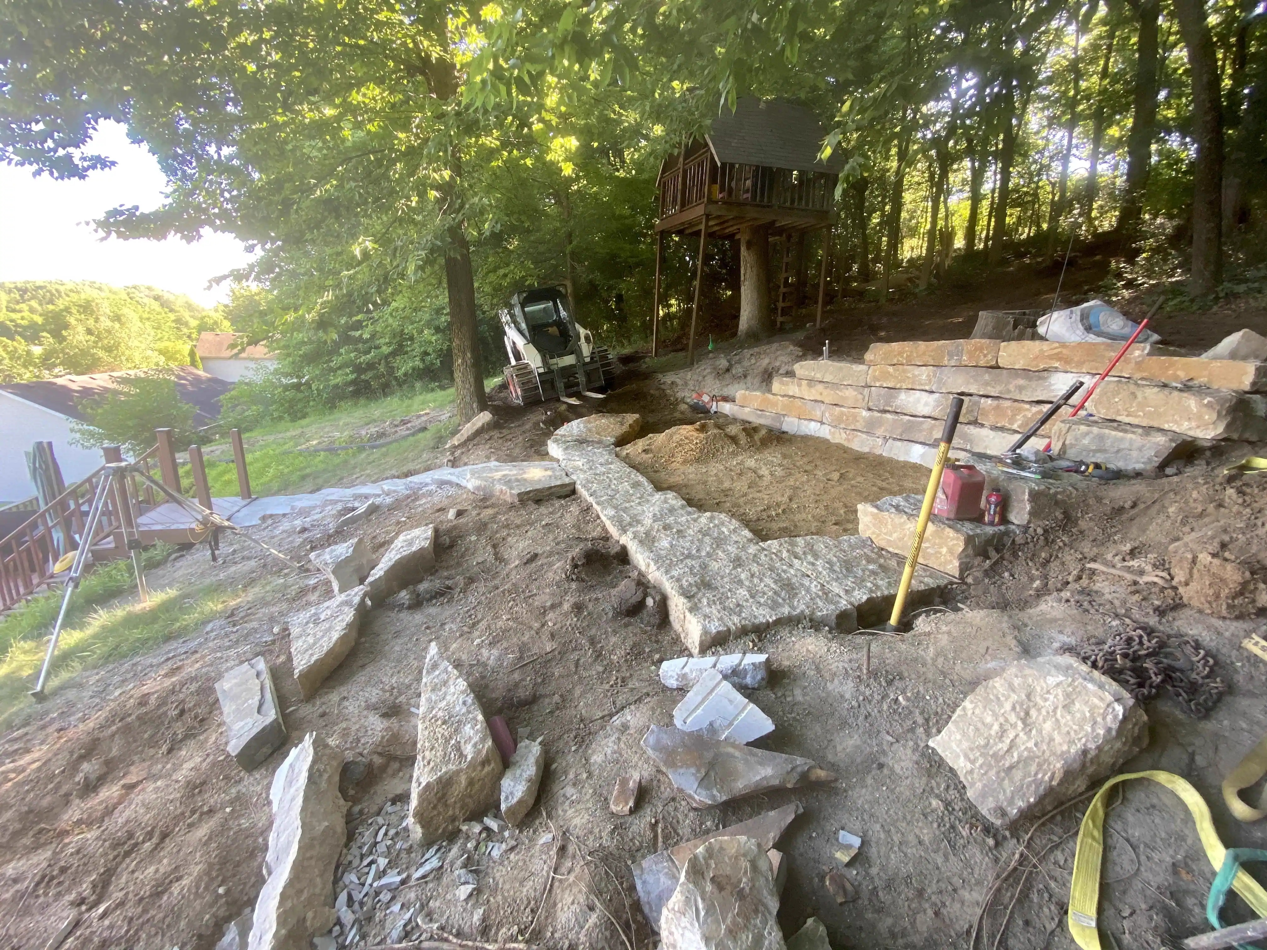 Drystone steps and wall under construction near a treehouse