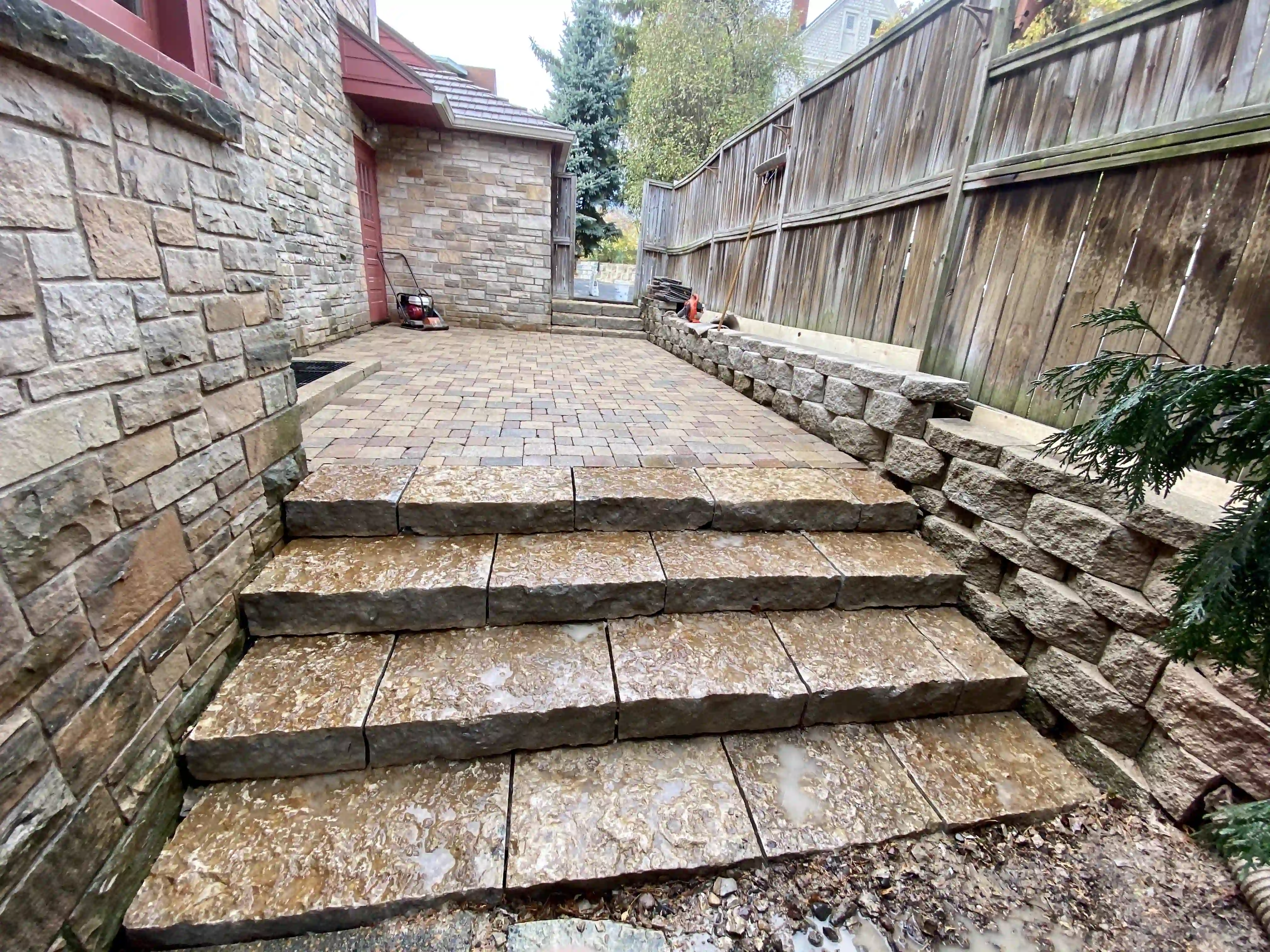 Stone retaining wall with finished paver patio