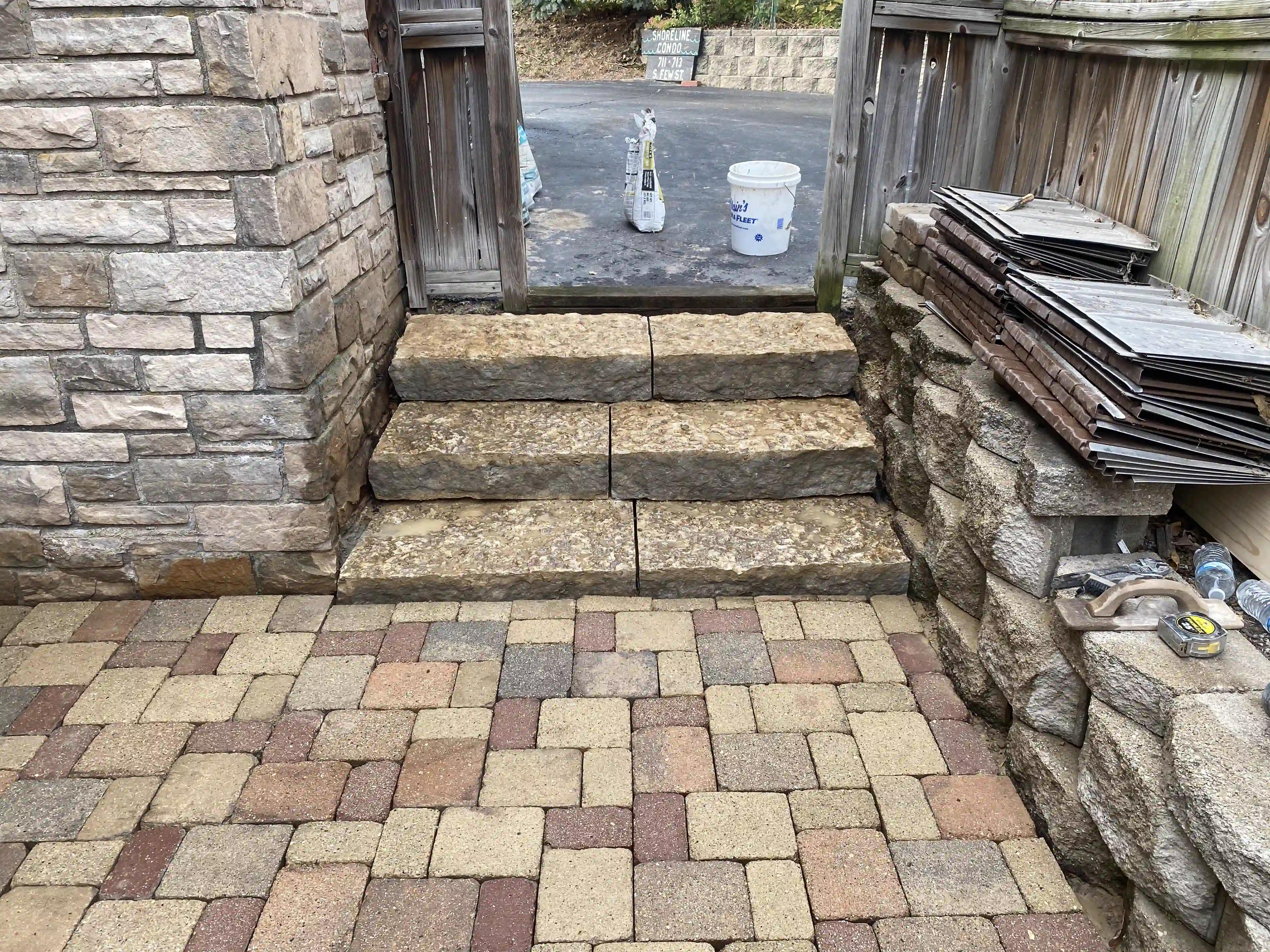 Stone retaining wall and pavers near a doorway entry