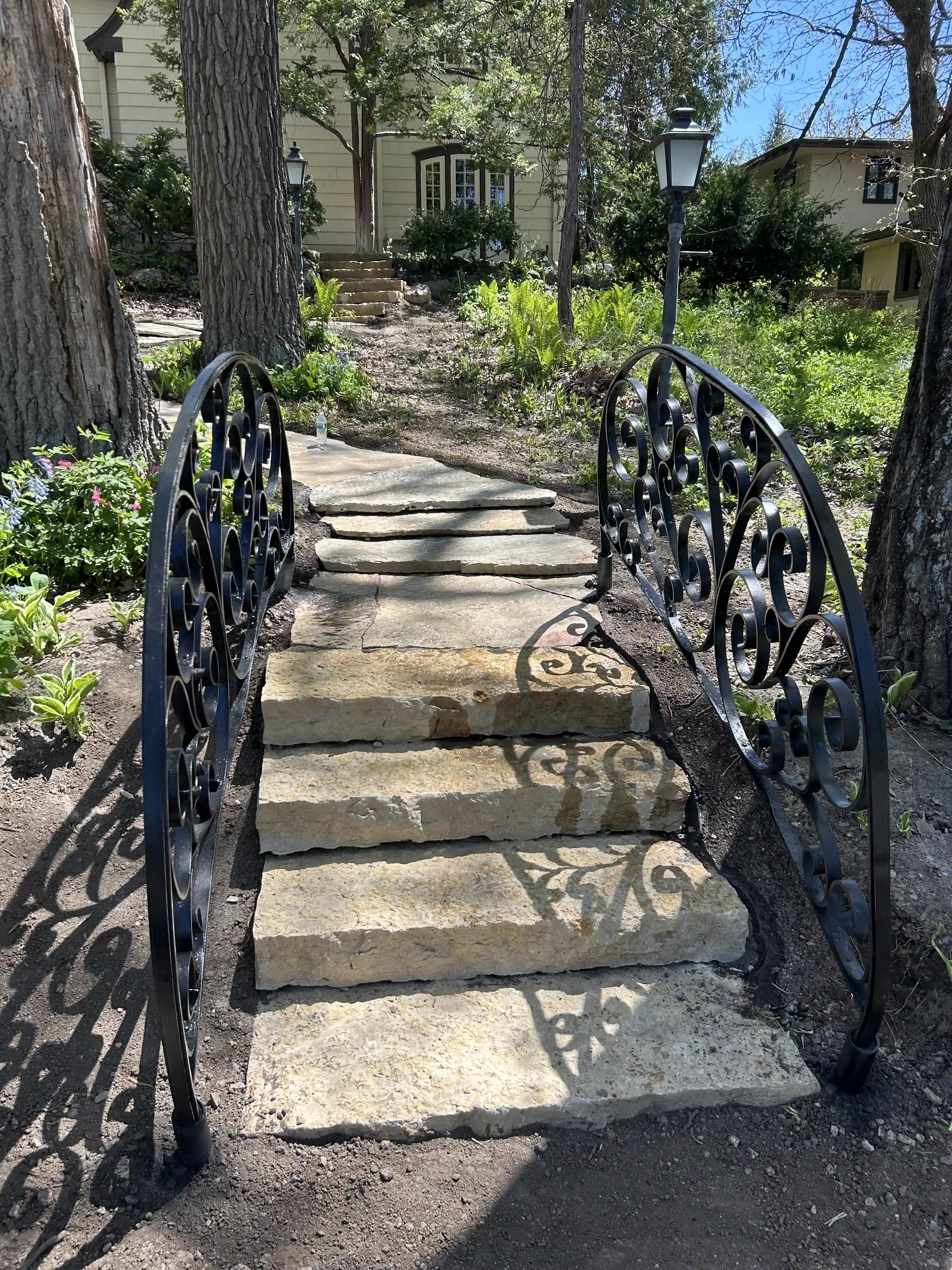 Wrought-iron arch over natural stone garden steps