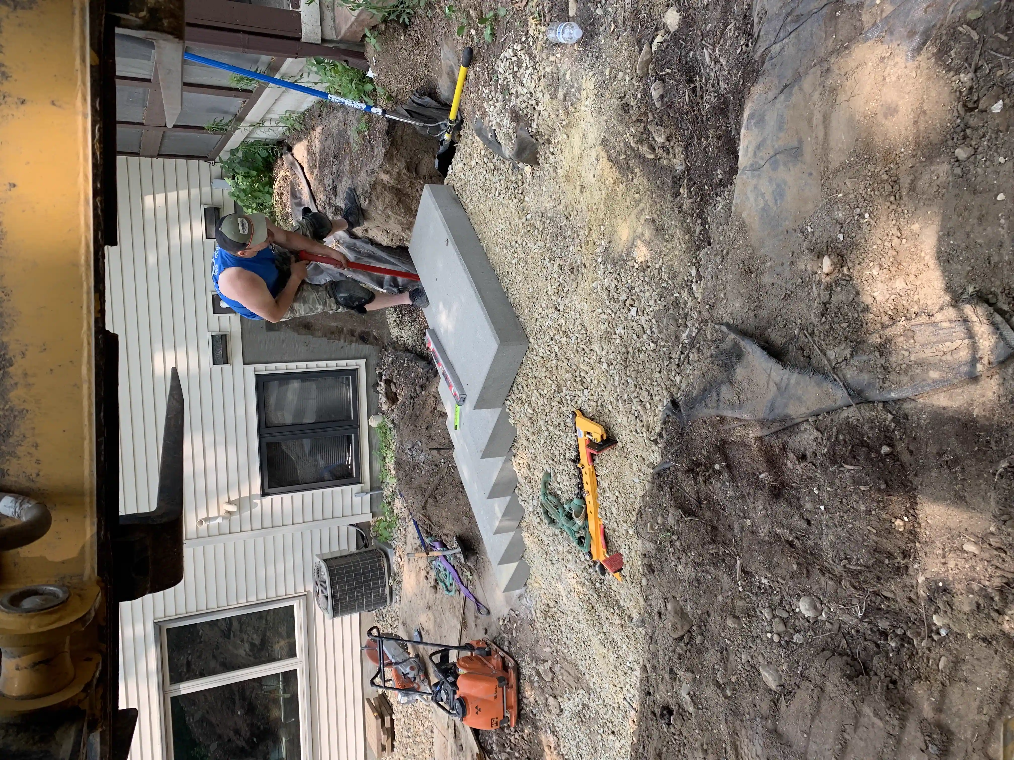 Stone retaining wall partway through construction